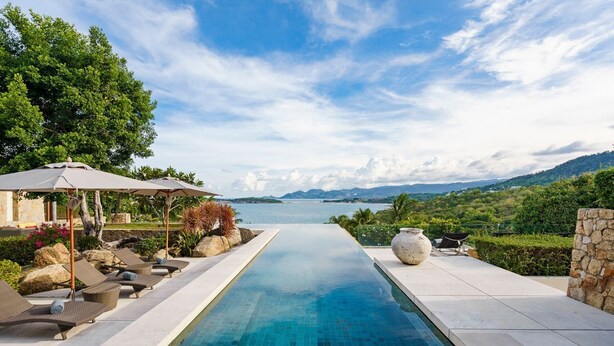 A swimming pool with lounge chairs and a view of a lake and mountains. - Samujana Villas - Villa Karawek (Bo Put)