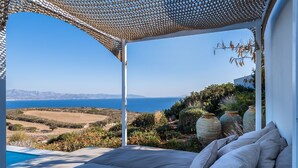 Un dormitorio con vistas al mar, una pérgola y una piscina.