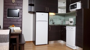 A modern kitchen with dark cabinetry, a white refrigerator, a microwave, a coffee maker, and a tiled backsplash. - Wifi, 300m from shops, parking, tv, ski locker, 35m², Val Cenis (Val Cenis)