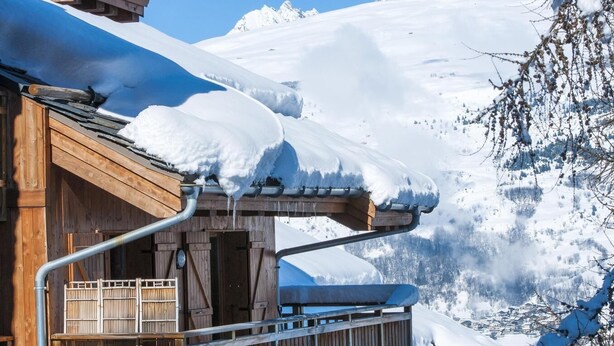 A wooden cabin with a snow-covered roof and a wooden balcony. - 150m from ski slopes, swimming pool, balcony, tv, ski locker, 50-55m², Montchavin La Plagne (Bellentre)