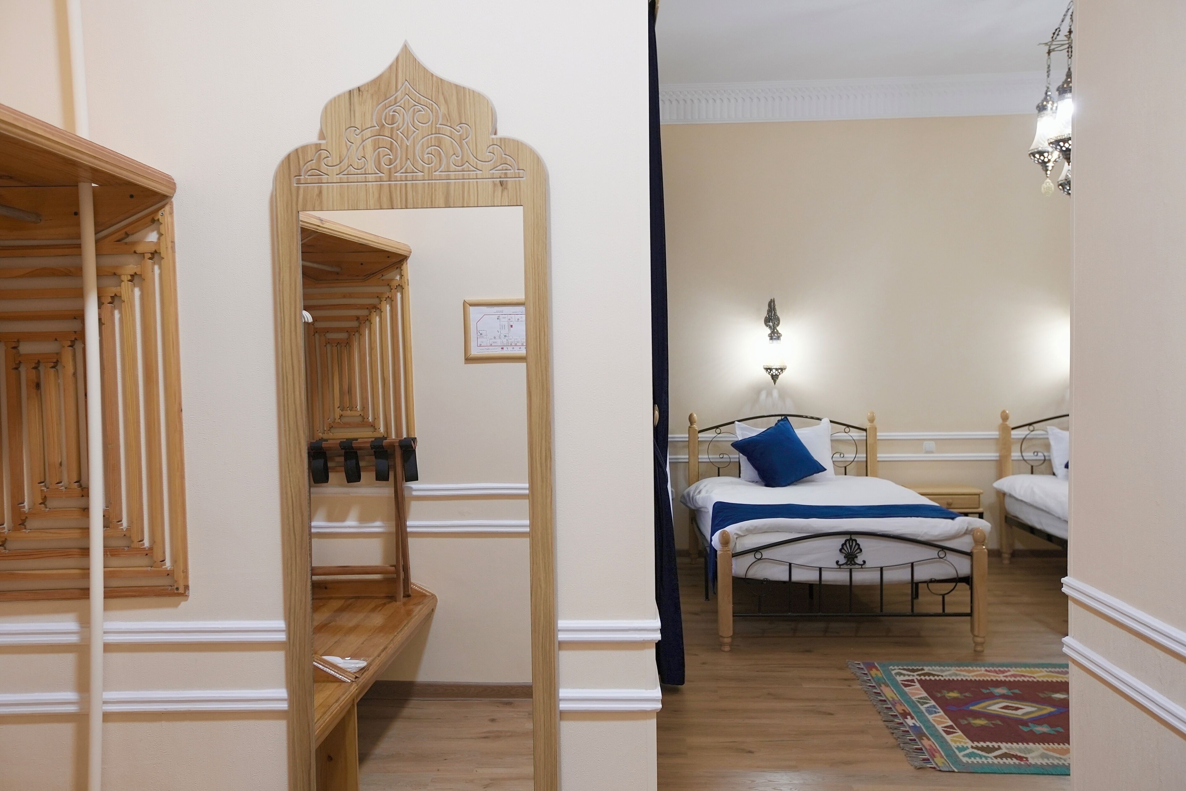 A bedroom with a wooden staircase, a bed with a blue pillow, and a patterned rug.