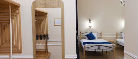 A bedroom with a wooden staircase, a bed with a blue pillow, and a patterned rug.