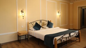 A bedroom with a bed, nightstands, and wall sconces. - Zargaron Boutique Hotel (Bukhara)