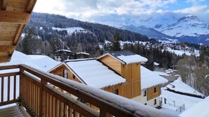 A wooden cabin with a balcony overlooking a snowy mountain landscape. - Ski-in/ski-out & foot of the slopes, swimming pool, terrace, balcony, tv, 35m², Combloux (Combloux)