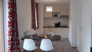 A compact kitchen with a microwave, coffee maker, and a dining area with a table and chairs. - Ski-in/ski-out & foot of the slopes, swimming pool, terrace, balcony, tv, 35m², Combloux (Combloux)