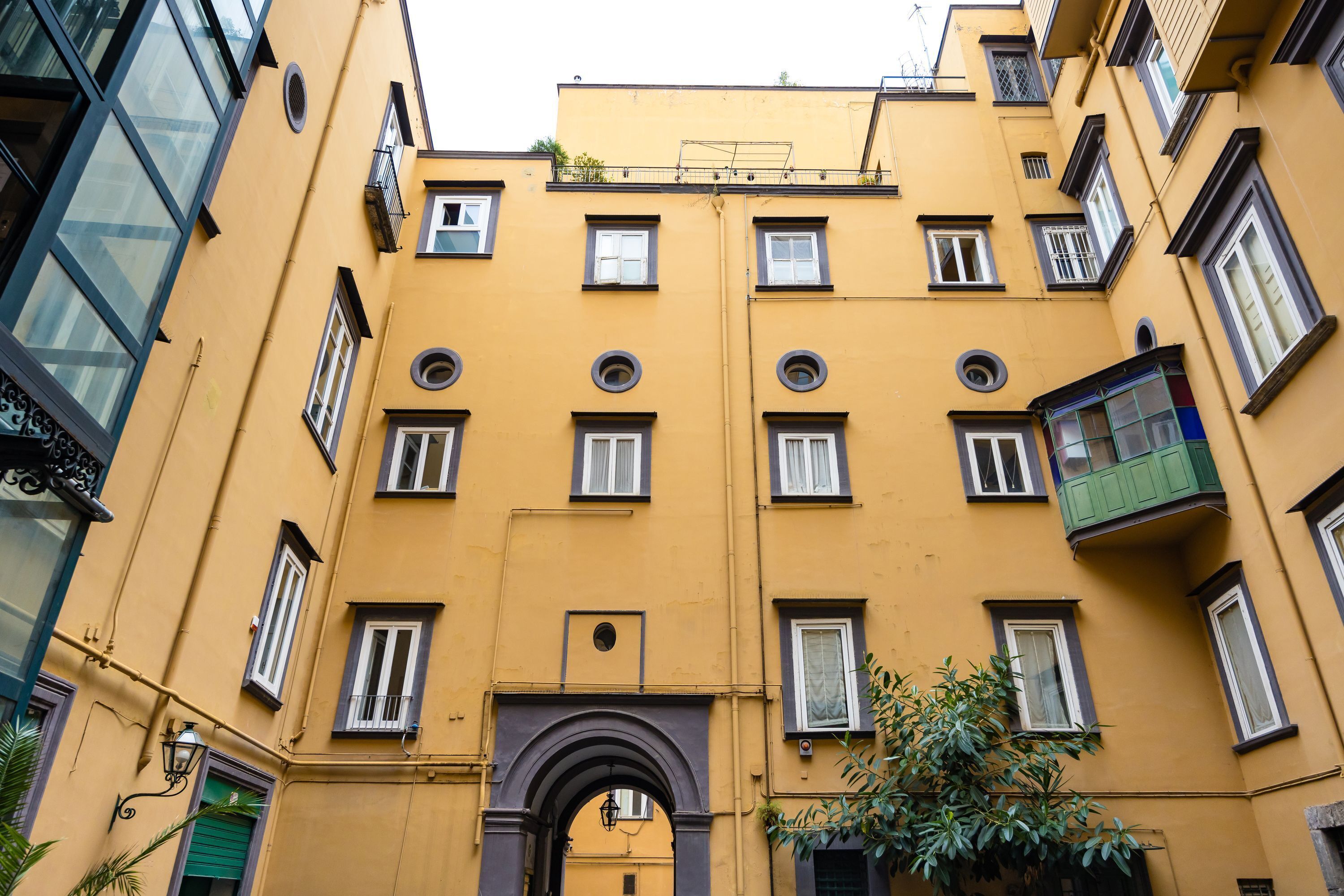 Un bâtiment jaune doté de nombreuses fenêtres et de balcons.