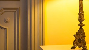 A room with a white door, a black lamp on a white table, and a yellow wall. - Bisignano 11 in Naples (Naples)