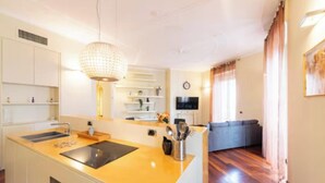 Cozinha moderna com ilha central, armários embutidos e área de refeições com sofá.