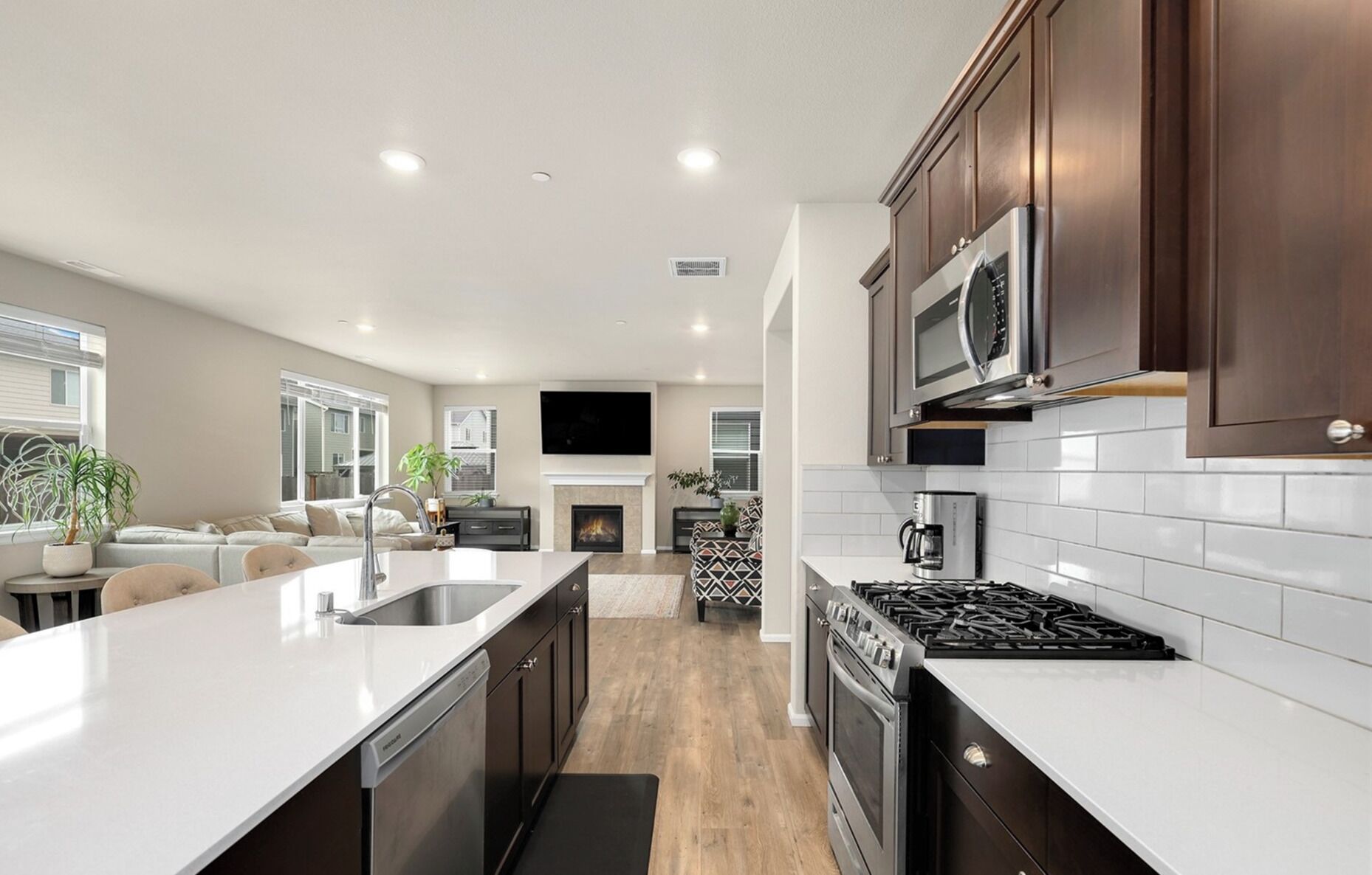 A modern kitchen with a central island, stainless steel appliances, and dark wood cabinets.
