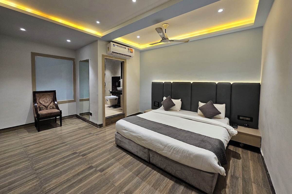 A modern bedroom with a large bed, a ceiling fan, recessed lighting, and a walk-in closet.