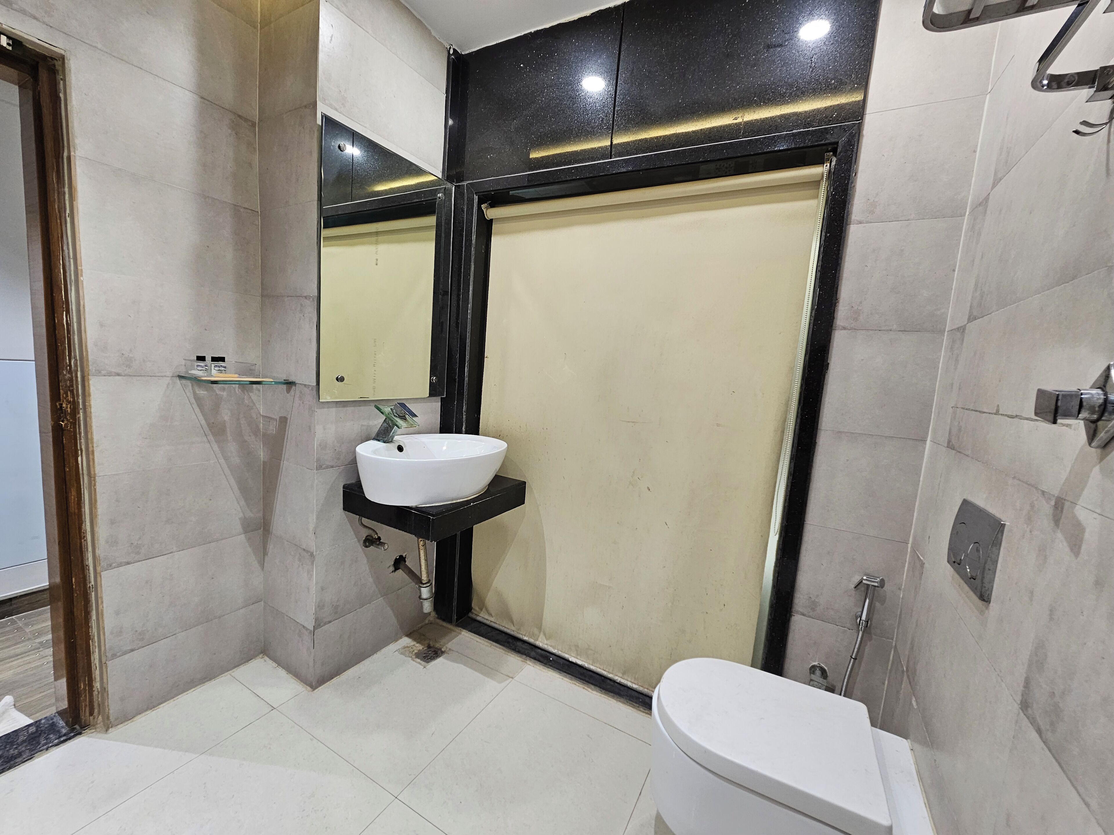 Un baño moderno con lavamanos blanco, inodoro y zona de ducha.