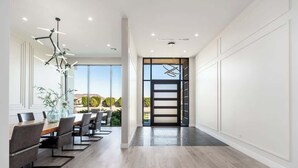 A modern interior with a dining area, large windows, and a view of the outdoors.