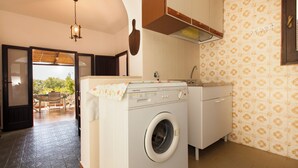 Un área de lavandería compacta con lavadora, lavabo y gabinete.