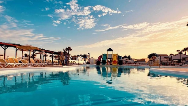 Uma piscina com espreguiçadeiras e um toboágua.