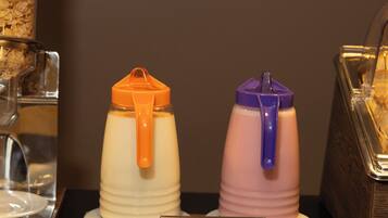 A yogurt display with two containers, one orange and one purple, on a counter with a sign labeled "Yogurt."