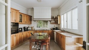 Una cocina con armarios de madera, una isla central y un ventanal que proporciona luz natural.