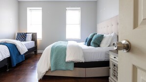Une chambre avec deux lits, une fenêtre et une porte.