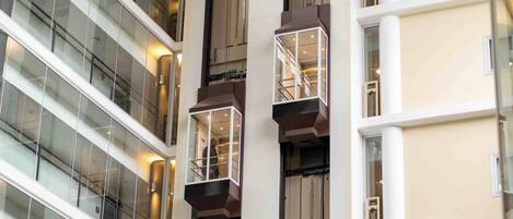 A multi-story building with glass railings and a central elevator shaft.