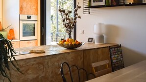 A kitchen counter with a fruit bowl, a coffee maker, and a plant. - Modern villa with pool in the heart of Provence, 30 minutes from the beaches (Carnoules)