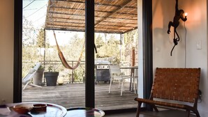 A room with a large window, a hammock, a grill, and a woven bench. - Modern villa with pool in the heart of Provence, 30 minutes from the beaches (Carnoules)