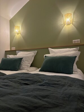 Relax in a stylish room with a large bed, shelf, and modern lighting fixtures.