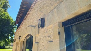 A building with a stone facade, large windows, and a small lantern on the wall. - Superb barn in the Dordogne, in the heart of Trémolat (Trémolat)