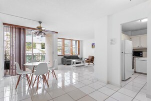 A modern kitchen with white cabinets, a refrigerator, and a microwave.