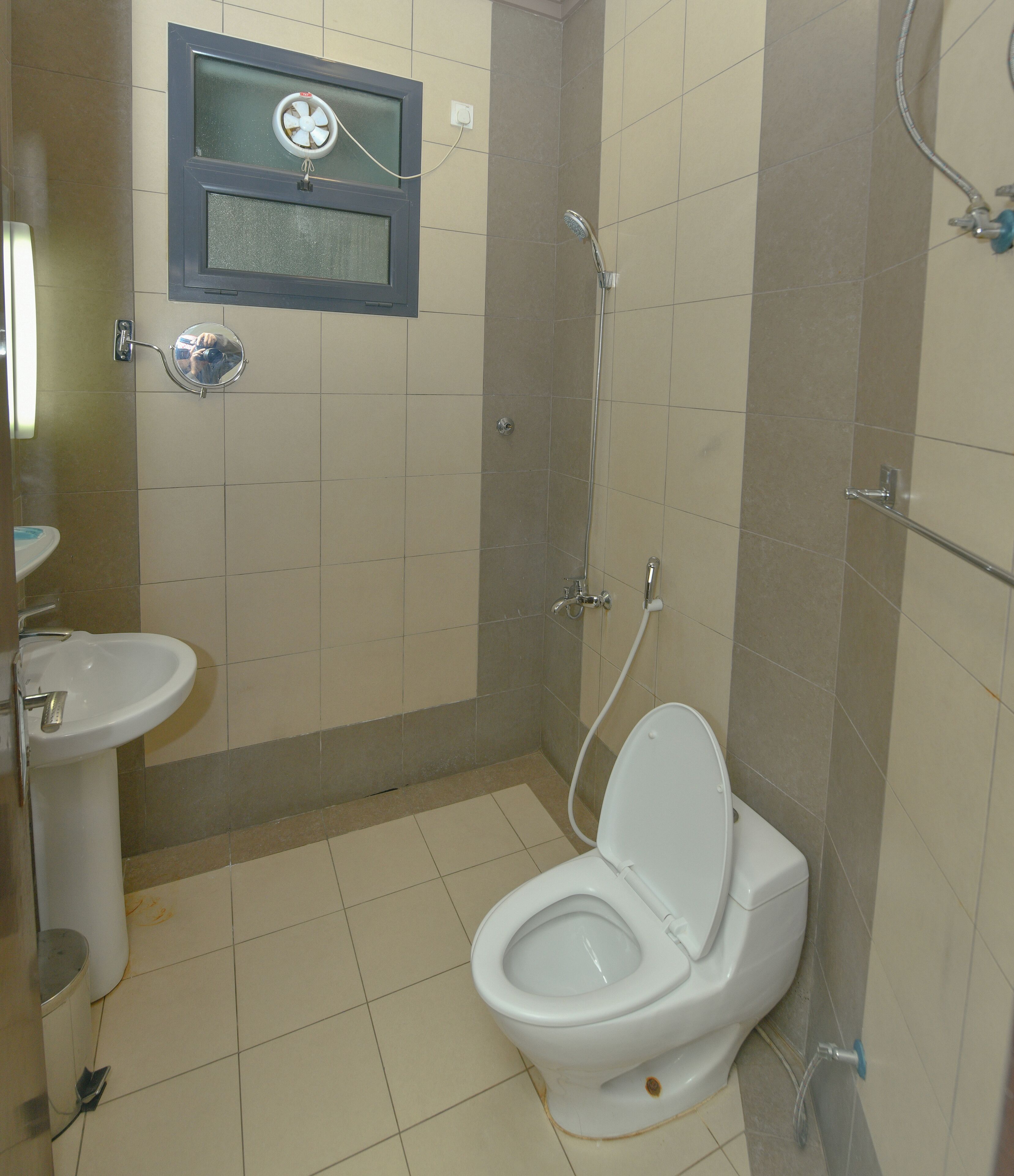 A bathroom with a toilet, sink, and shower.