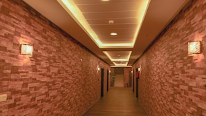 A long, narrow hallway with brick walls and wooden flooring, leading to a staircase at the end. - Reef Al Kharj Hotel Apartments (Al Kharj)