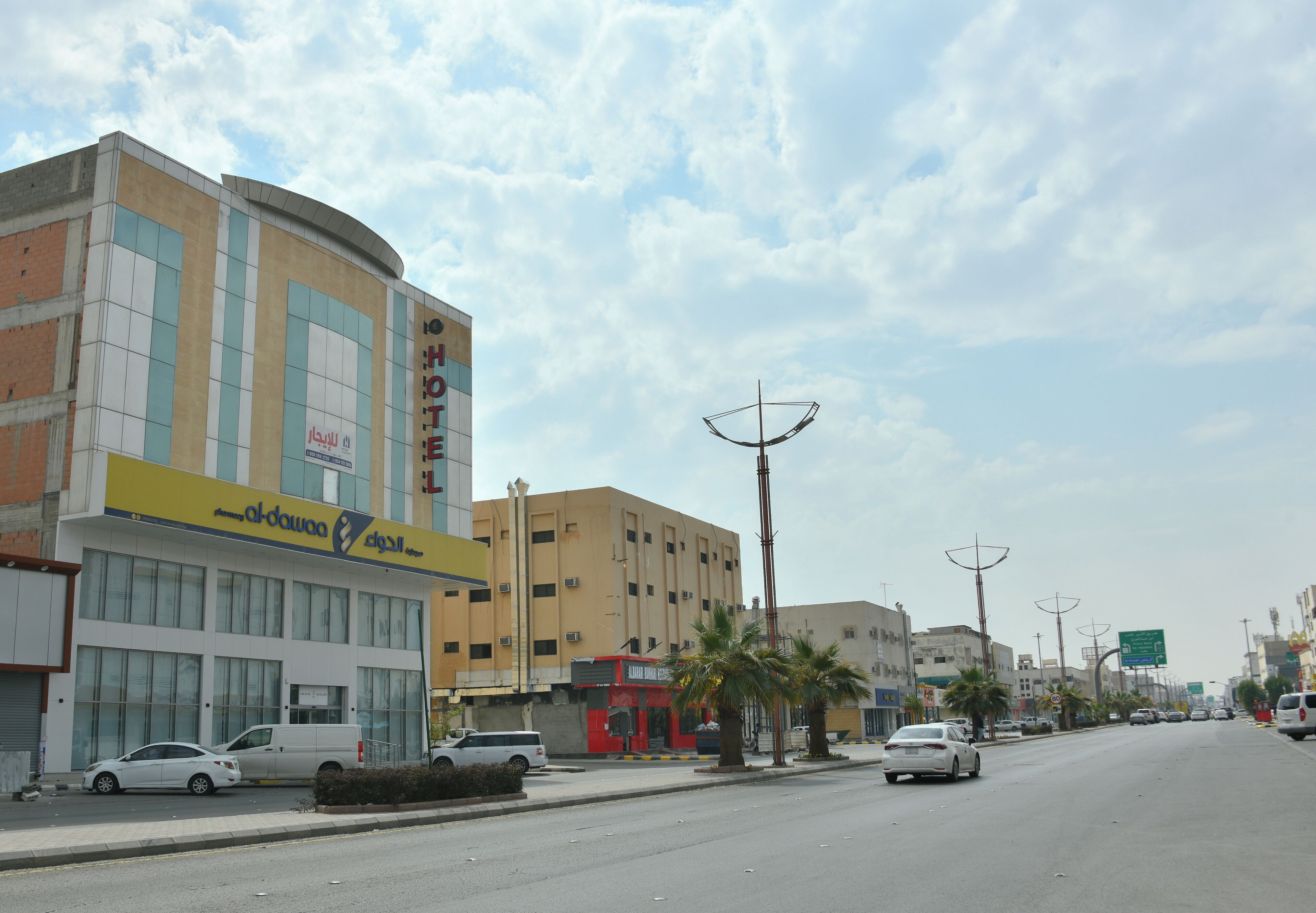 A hotel with a modern facade, multiple floors, and a prominent sign.