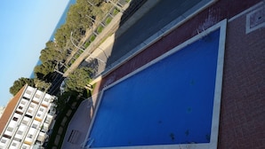 A swimming pool adjacent to a building with a red brick facade.