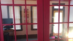 A red-framed door leading to a room with a desk, chair, and a lamp. - Poe Themed Home Close to Beaches and DE Turf (Milford)
