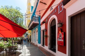 Una calle estrecha con mesas al aire libre y un restaurante llamado "MUELLE 13".