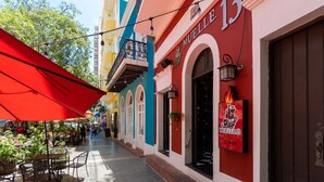 A narrow street with outdoor seating and a building with 'MUELLE 13' signage.