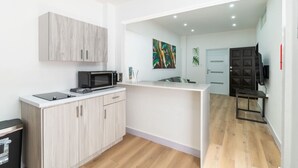A compact kitchen with a microwave, cabinets, and a small countertop.