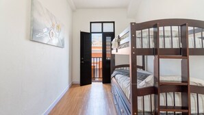A narrow hallway with a bunk bed and a door leading to an outdoor balcony. - Modern 2-BR Apt. in historic Old San Juan (San Juan)