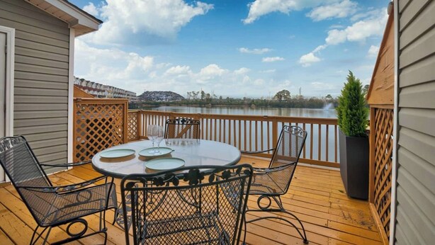 A deck with a table and chairs overlooking a lake. - Lakeside Landing Spacious Comfort  Near Downtown (North Charleston)