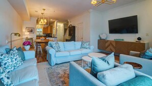 A modern living room with a sofa set, a dining area, and a kitchen in the background. - Lakeside Landing Spacious Comfort  Near Downtown (North Charleston)