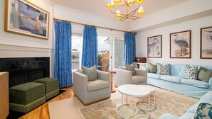 A modern living room with a fireplace, a sofa set, a coffee table, and artwork on the walls. - Lakeside Landing Spacious Comfort  Near Downtown (North Charleston)