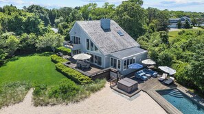 A modern two-story house with a large deck, outdoor seating, and a swimming pool. - Amazing Beachfront Water Mill Home with Private Pool and Hot Tub, Perfect... (Water Mill)