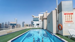 Piscina no terraço com vista para o horizonte urbano.