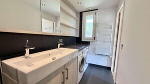 A modern bathroom with a double sink, a washing machine, and a mirror above the sink. - 2nd floor, balcony, tv, ski locker, 55m², Praz sur Arly (Praz-sur-Arly)