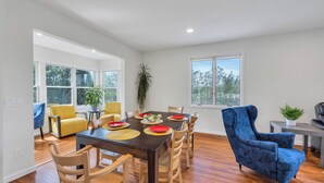 A dining area with a wooden table, yellow chairs, and a blue armchair. - Cozy North Fork Home Among the Best Wineries in the Northeast, Minutes to... (Aquebogue)