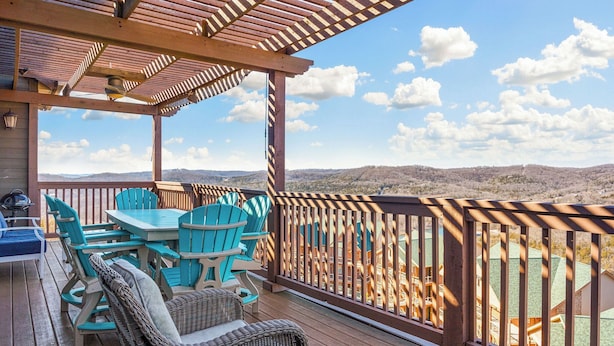 A wooden deck with outdoor furniture, a pergola, and a view of a mountainous landscape. - Penthouse Table Rock Lake View  Near SDC (Branson)