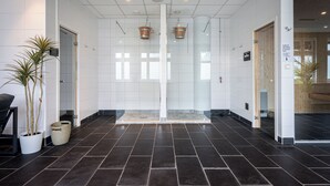 A modern hotel lobby with a tiled floor, a reception desk, and a glass partition. - Injoy Compact Hotel Solna (Solna)