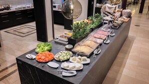 A buffet with various food items and a modern kitchen in the background. - Injoy Compact Hotel Solna (Solna)