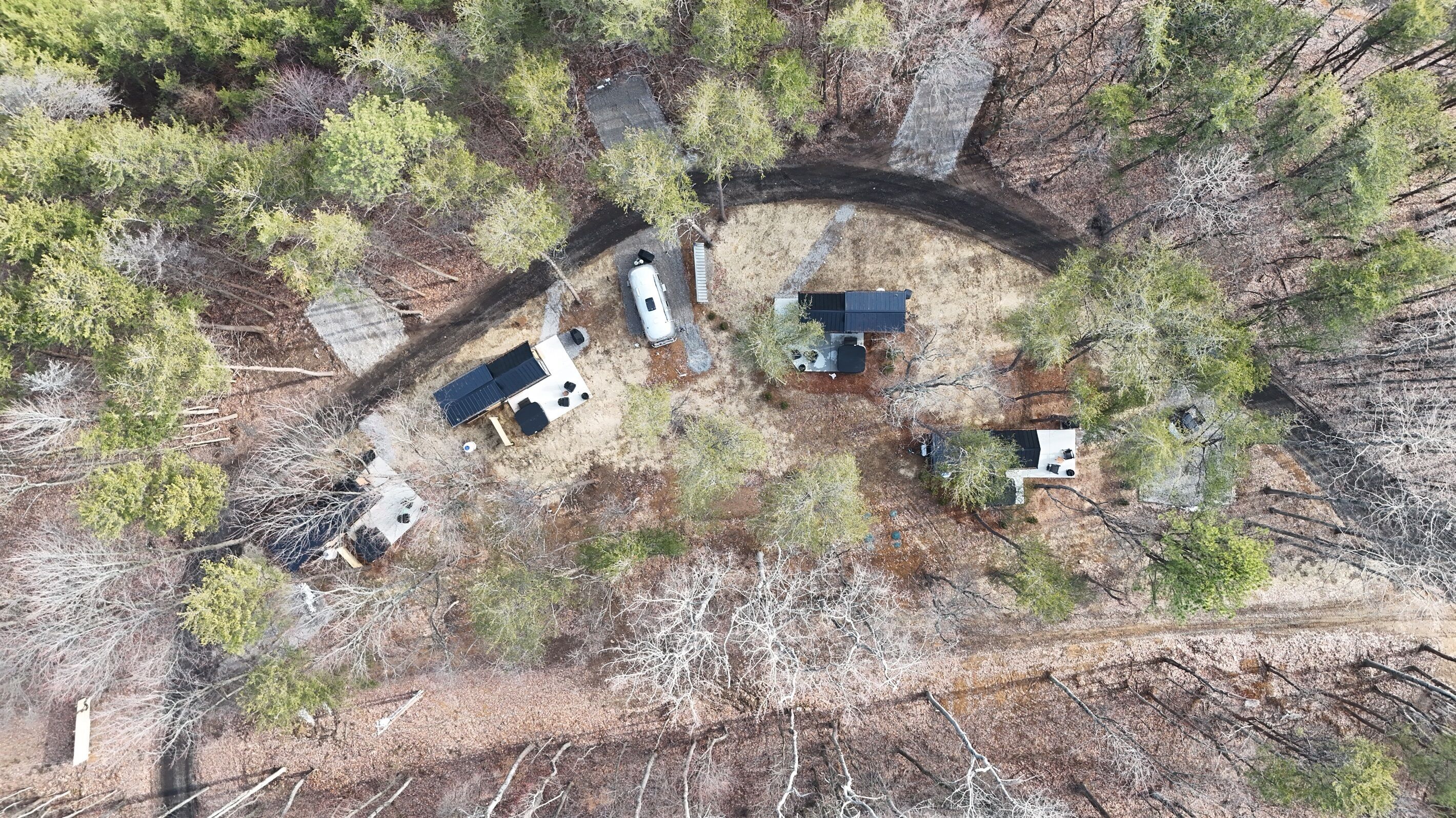An aerial view of a campsite with tents, a solar panel, and a vehicle.