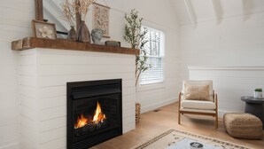 Un salon chaleureux avec une cheminée, un fauteuil confortable et une cheminée décorative.