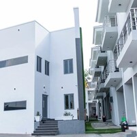 Um edifício moderno com fachada plana, várias janelas e um elemento vertical central.
