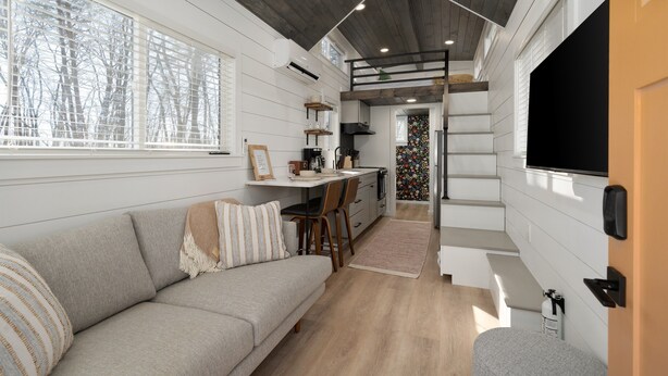 Ein modernes Interieur mit einer Couch, Essbereich und Küche.